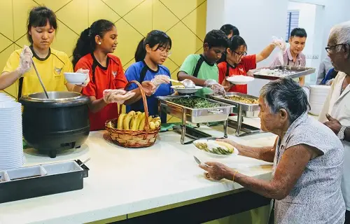 International School KL students distributing food to old folks at charity centre