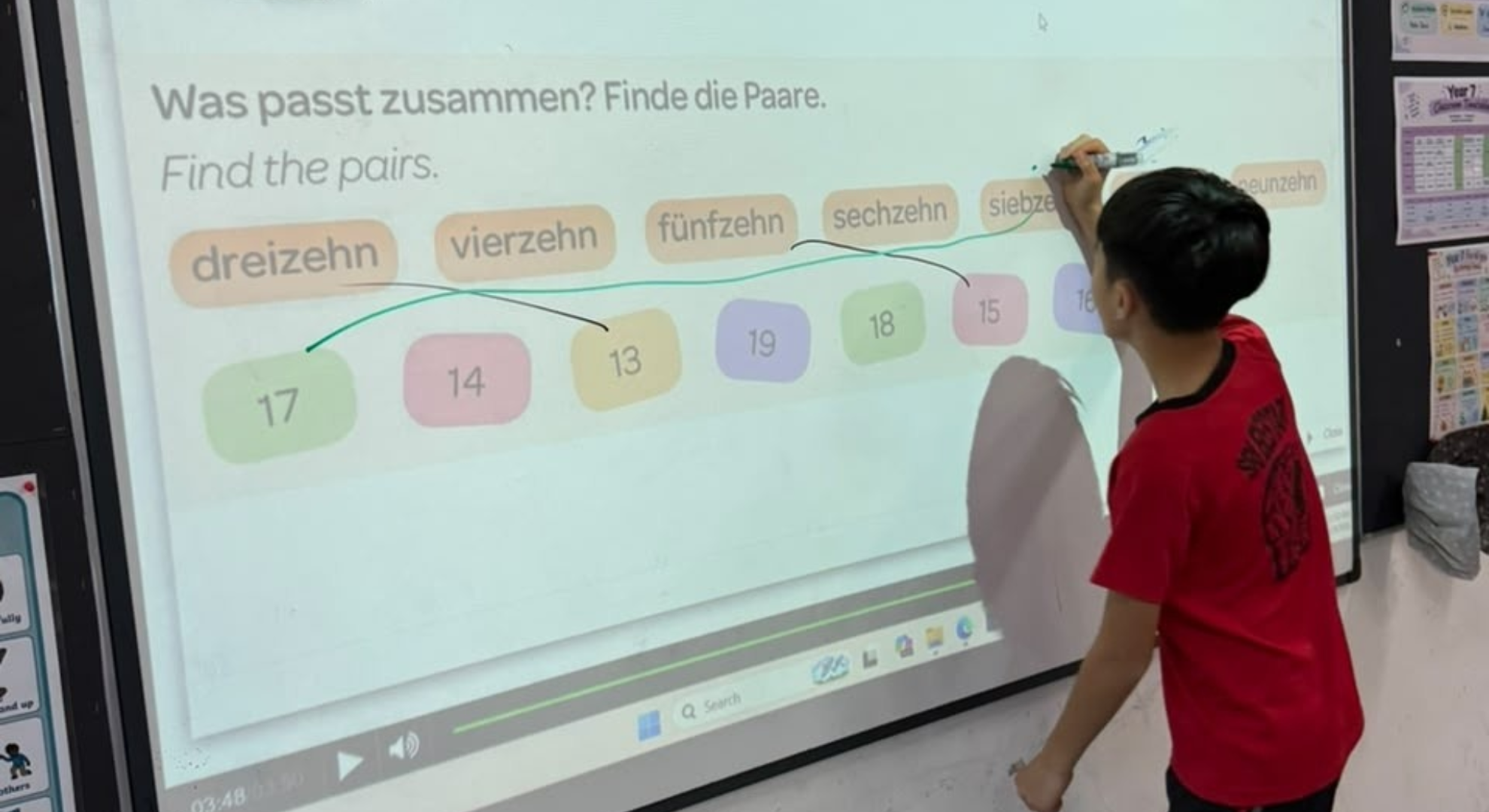 SBIS student matching German words on an interactive whiteboard in a German lesson